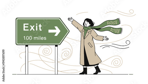 Woman in a beige coat standing next to an exit sign on a windy day