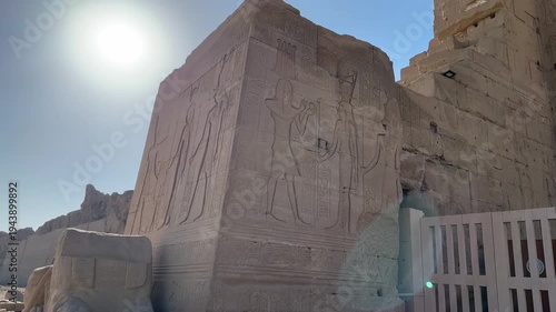 Close-up of a large ancient stone block featuring detailed reliefs of Egyptian deities and hieroglyphs in the archaeological area of Dendera Temple