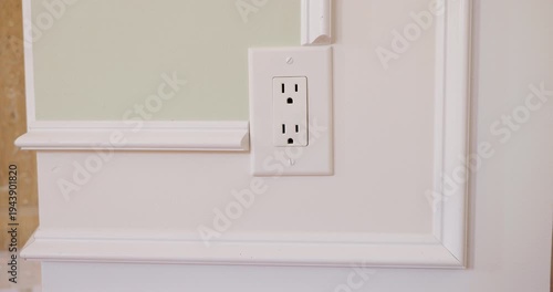 Hand plugging and unplugging American type power plug in wall outlet