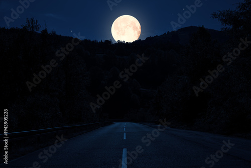 Moonlit countryside two lane road at night.