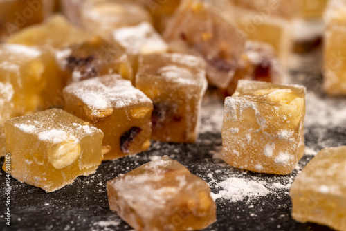 soft and fresh Turkish delight sprinkled with a small amount of powdered white sugar, sweet white soft pieces of Turkish delight with nuts and dried fruits, yellow-orange sweetness
