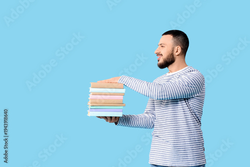 Young man with stack of boo...
