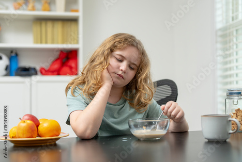 Kid with no appetite at home. Child refusing food. Kid showing loss of appetite. Child with poor appetite indoors. Kid not eating breakfast. Child pushing plate away. Kid struggling with appetite.