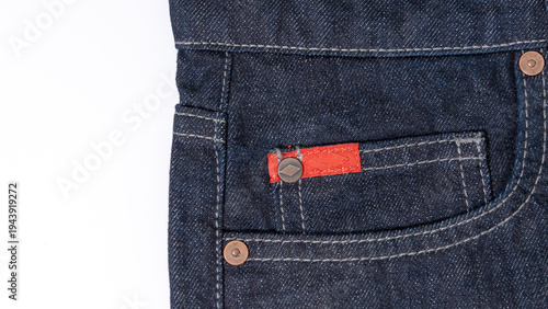 Canvastavla Fashionable dark blue denim pocket detail with copper rivets and a red label, providing a clean and professional look for clothing and textile concepts