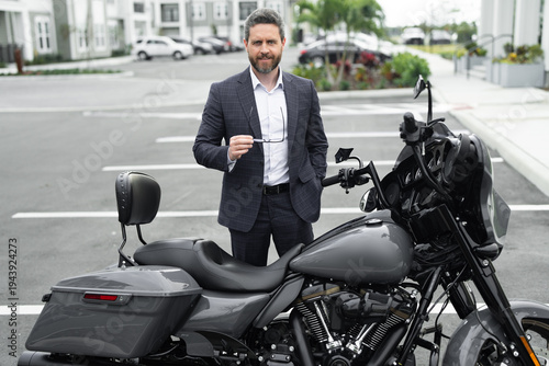 Businessman portrait with stylish suit outdoors. Businessman lifestyle near motorbike in city. Businessman career concept with strong authority. Businessman symbol of corporate leadership.