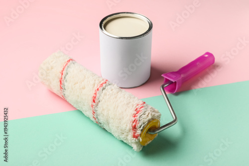 Roller with can of white pa...