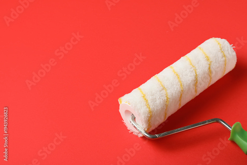 Paint roller on red background