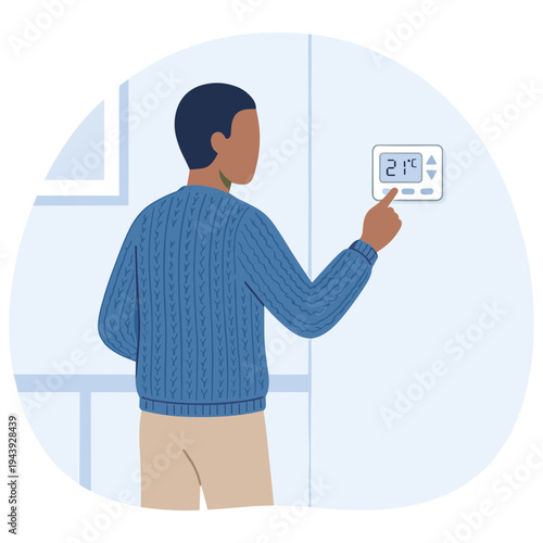 Man adjusting thermostat on wall indoors