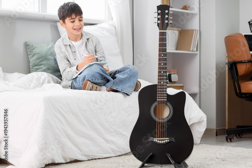 Cute boy writing music note...