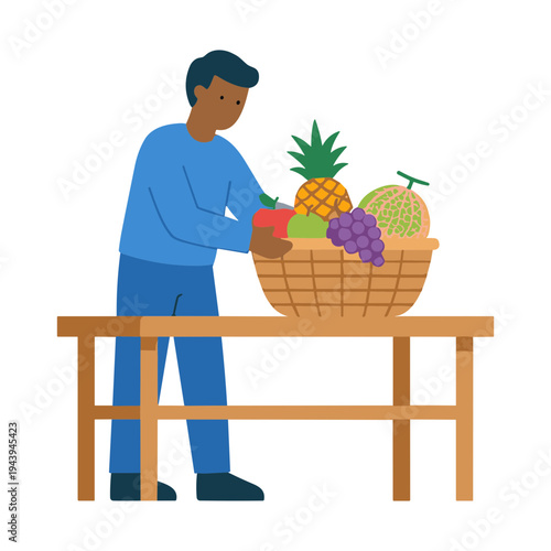 Man arranging colorful fruit basket on wooden table indoors