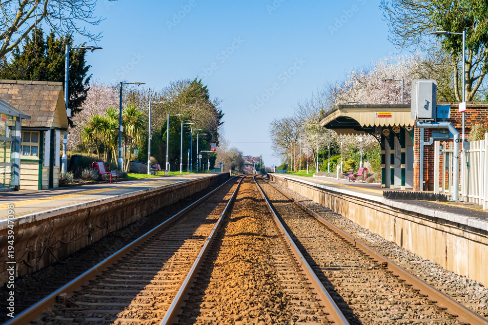 Obraz premium Train line and small train station in the UK during Spring