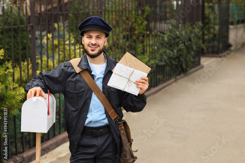 Handsome postman with lette...
