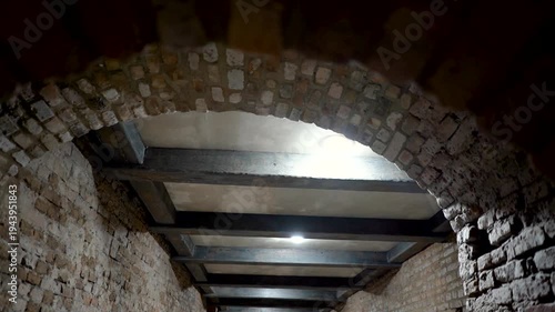 Interior of a brick wall corridor in a historic building with exposed old brick walls and a rustic, unfinished look