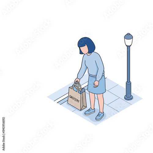 A woman picks up her shopping bag on a city sidewalk at night.
