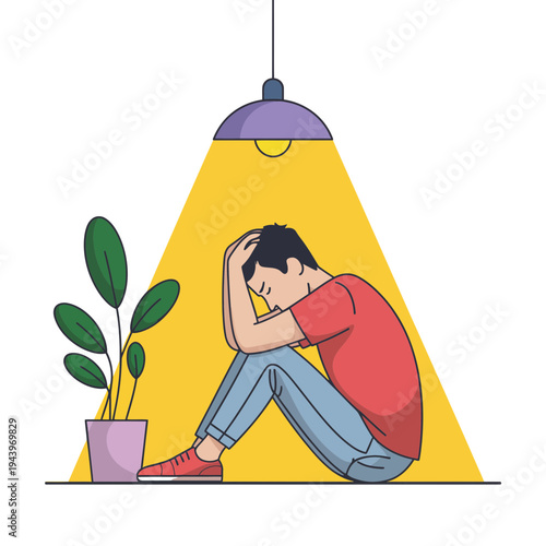 A man sits dejected under a hanging light beside a plant