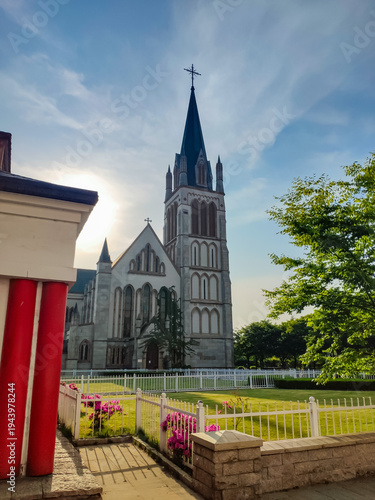 Church with lawn in front, under sunny blue sky