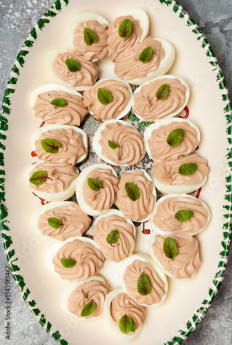 stuffed eggs and green leaves on a oval plate, image from above