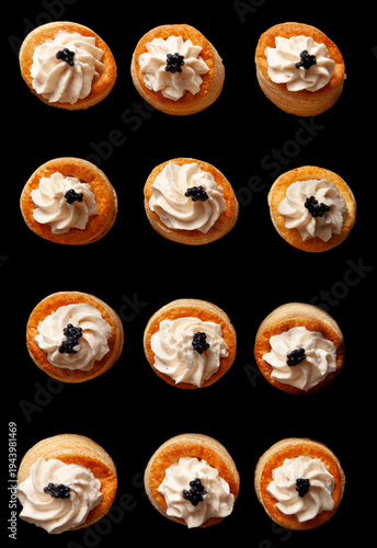 Vol au vent appetizers with cream cheese and roes on a black board, image from above