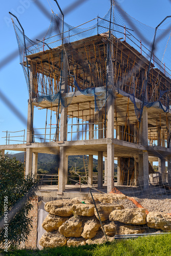 Real Estate Development And Construction Boom Unfinished Concrete Building Structure With Scaffolding In San Enrique De Guadiaro Andalucia Spain Costa Del Sol