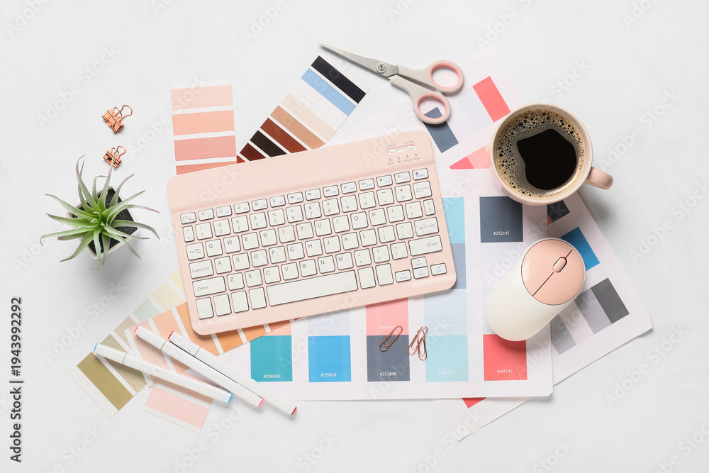Fototapeta premium Computer keyboard with mouse, cup of coffee, stationery and color palettes on white background, top view