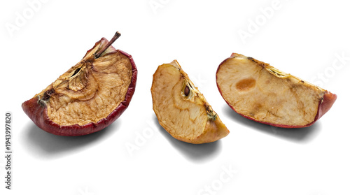 three desiccated apple slices, presented against a white, opaque transparent background, highlighting their wrinkled texture and aged appearance.