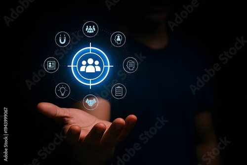 Person holding out their hand in a dark environment, displaying a glowing virtual icon of a target with a human group inside, surrounded by various customer-centric service icons.