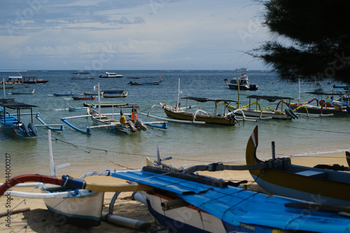 Traditional Balinese fishing boats in shallow water and on the beach
