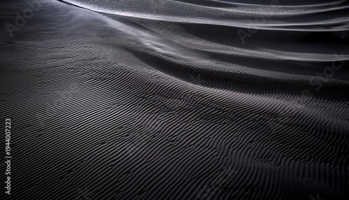 dunes of dark black sand stripes and ripples of smooth volcanic sand texture or wallpaper wave pattern in black sand background