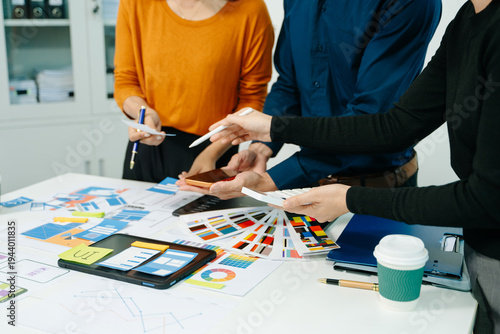  UX developer and ui designer brainstorming about mobile app interface wireframe design with customer breif and color code at modern office.