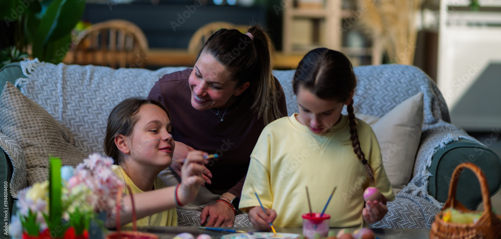 Ταπετσαρία Loving mother watching her two happy daughters painting colorful easter eggs tog