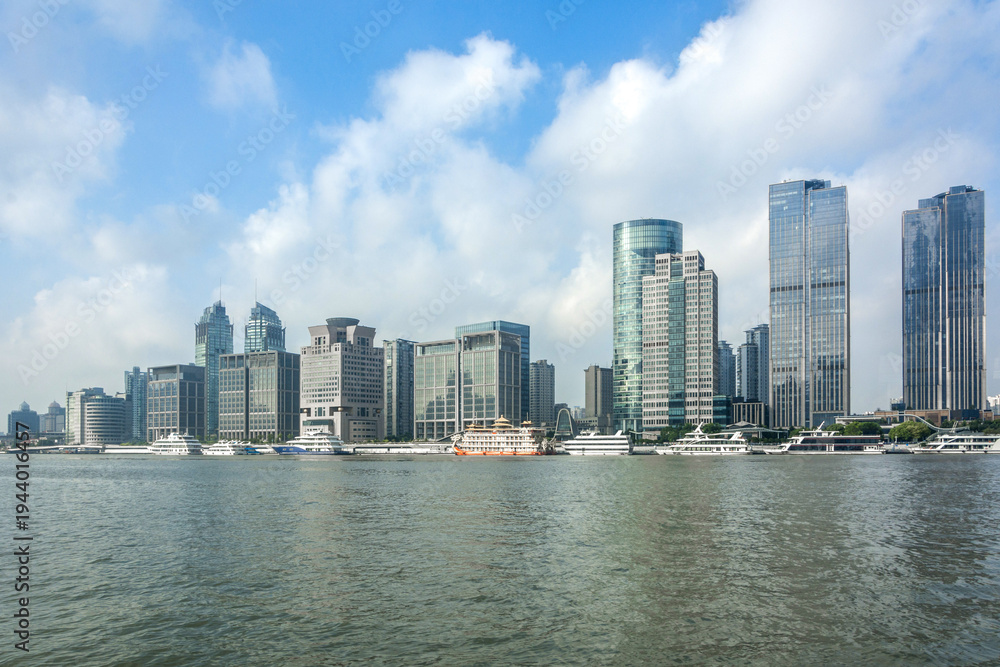 Obraz premium Modern Skyscrapers Along Urban Waterfront with Clear Blue Sky