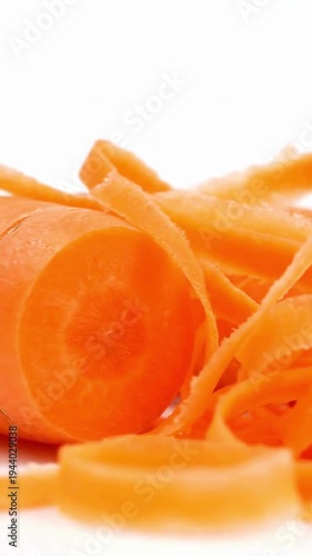Fresh Orange Carrot Slices and Peels on White Background