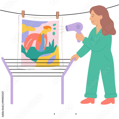 Woman uses hairdryer to dry colorful artwork on clothes rack indoors