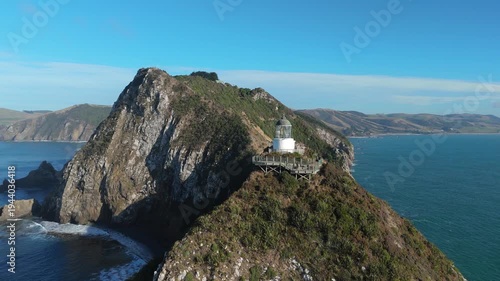 Aerial drone view of Nugget Point lighthouse on dramatic coastal cliffs in Otago New Zealand