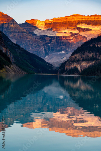 Sunrise reflecting on mountains over Lake Louise in Alberta