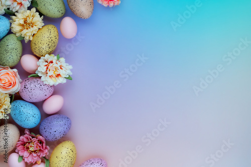 Easter background with pastel eggs and spring flowers corner composition on gradient backdrop