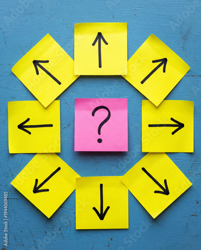 Question Mark on Pink Sticky Note Surrounded by Directional Arrows on Yellow Notes Over Blue Background, Decision Making and Choice Concept