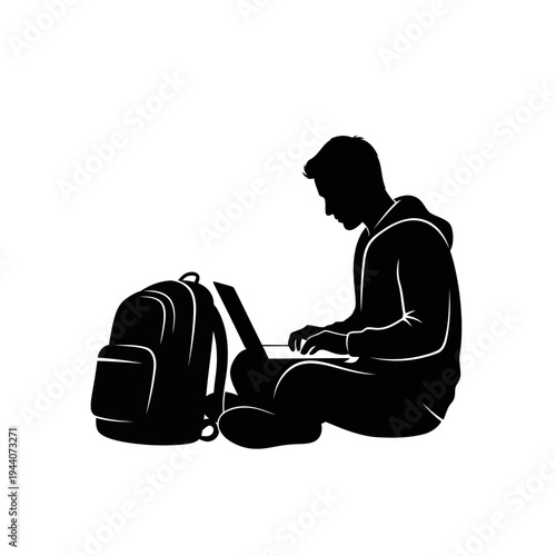 A man sits on the floor with a laptop and backpack