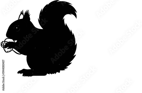 Black silhouette of a squirrel holding a nut, with a fluffy tail