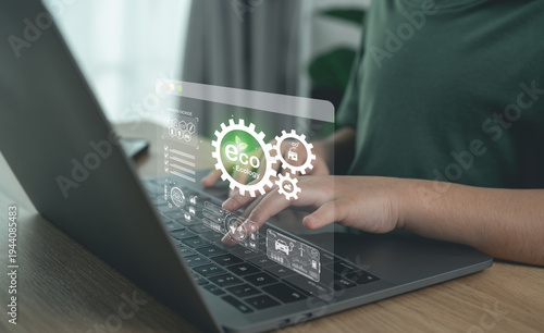 Person typing on laptop with virtual eco ecology and green energy sustainability icons overlay.