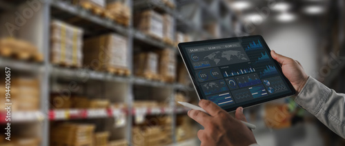 Logistics manager analyzing supply chain data dashboard on tablet inside warehouse storage facility. Concept of logistics analytics, inventory monitoring, digital warehouse management and technology d