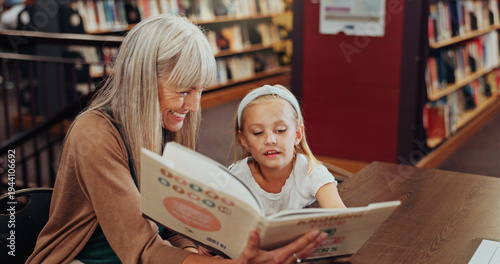 Фотография Grandmother, reading book and girl in library, storytelling and bonding together for child development