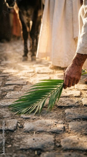 Palm Sunday procession with a person laying a palm frond on a stone path as Jesus enters Jerusalem.