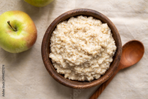 Healthy diet vegetarian breakfast: boiled oatmeal porridge in wooden bowl