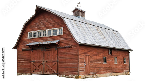 Fotografie Rustic red wooden barn with a corrugated metal roof and weathervane, isolated on