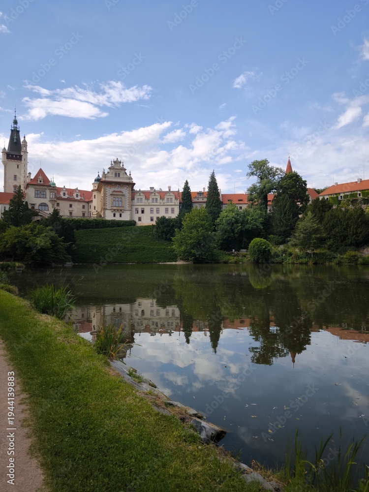 Obraz premium Scenic view of Pruhonice Castle in a sunny summer day with beautiful reflection in the pond,
