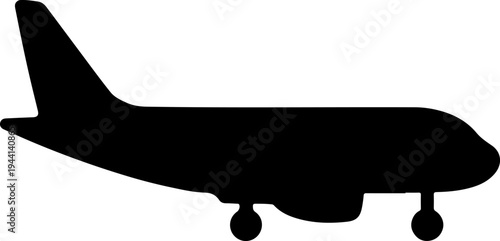 The silhouette of an airplane is flying through clear blue skies.