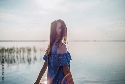 Young Woman with Hair Across Face at Sunset Lake