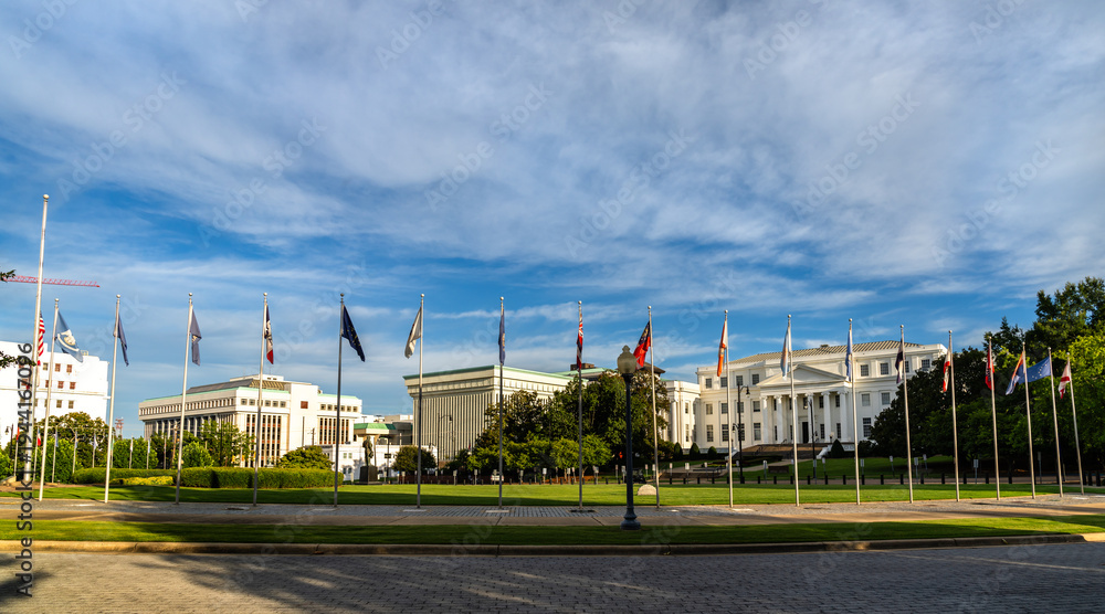 Naklejka premium Wide angle view of the Alabama State Capitol and the Avenue of Flags under a blue sky in Montgomery