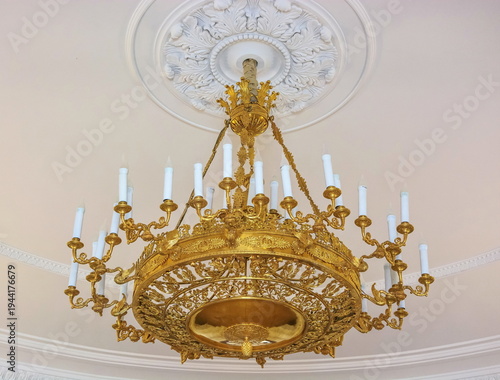 Forged golden chandelier stylized in antique style